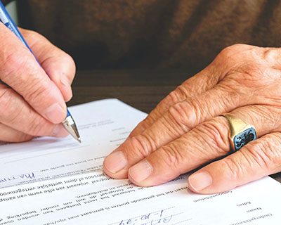 Older adult signing a financial document